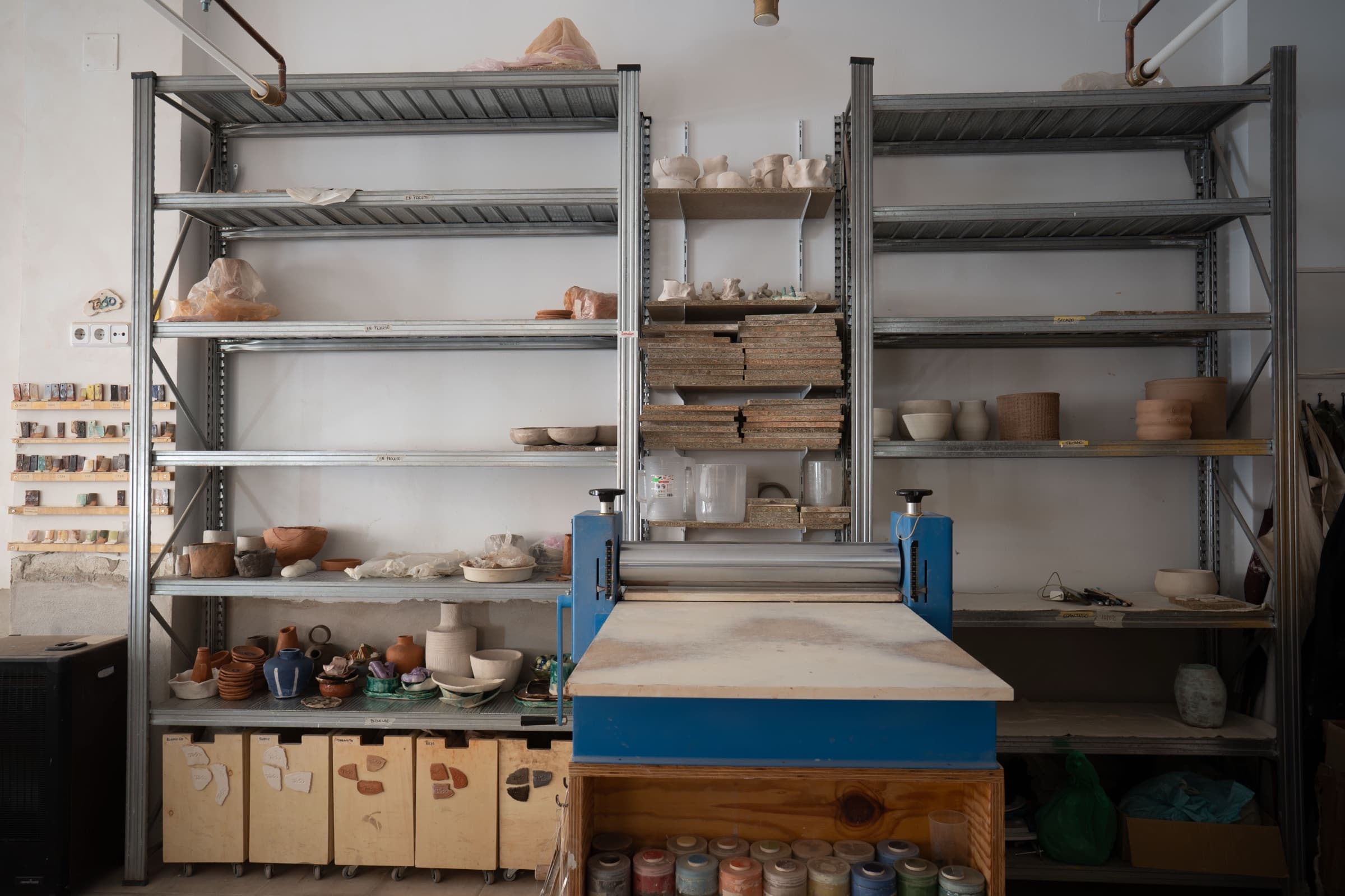 estanterías con piezas en proceso y la laminadora