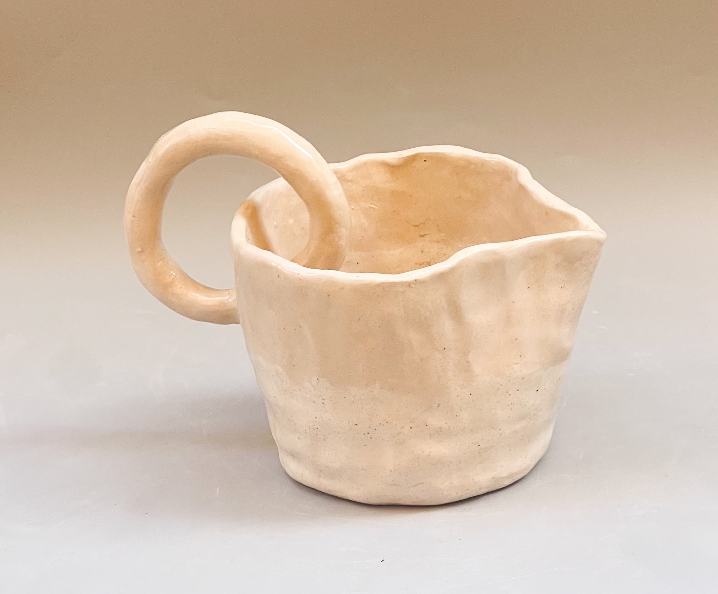 taza de cerámica en tono crema, vista de detalle